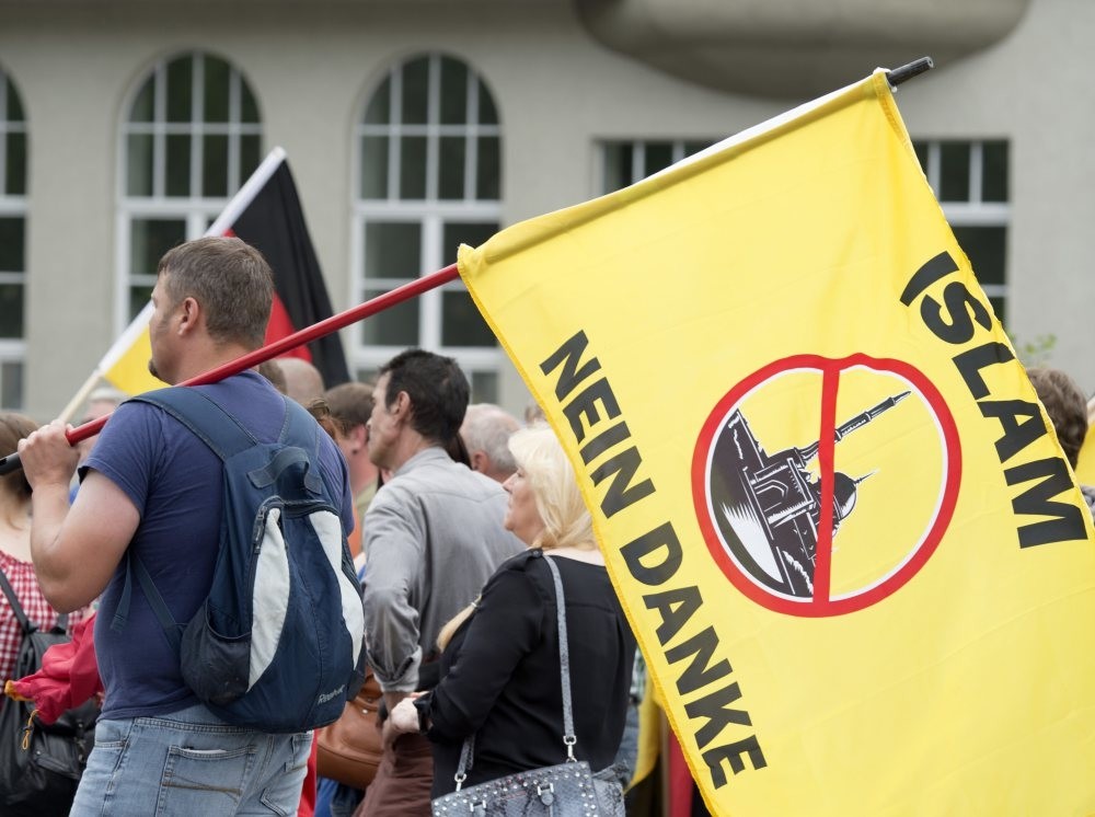 A supporter of the right-wing Patriotic Europeans say NO, holds a flag reading: ,Islam, No Thanks,, during a rally in Erfurt, Germany, June 4, 2016. 