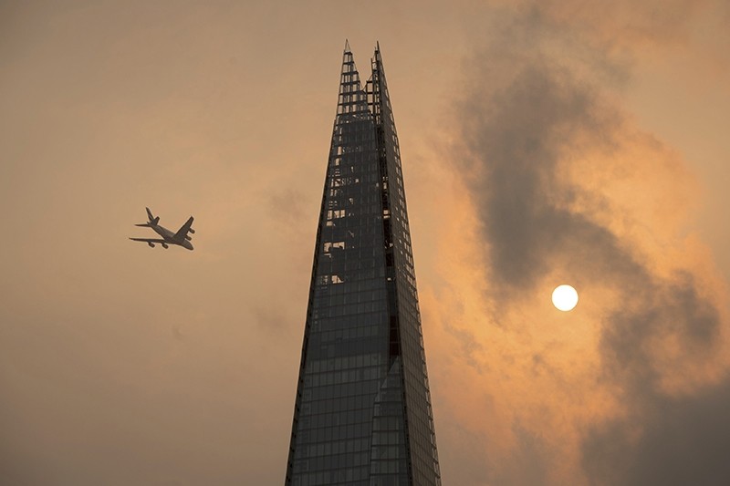 A plane flies past the Shard in central London, as the sky takes on an unusual orange colour caused by Hurricane Ophelia Monday Oct. 16, 2017.
