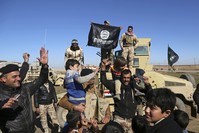 In this Jan. 24, 2017 file photo, Iraqi Army soldiers celebrate with residents of liberated neighborhoods as they hold upside down a banner of Daesh (AP Photo)