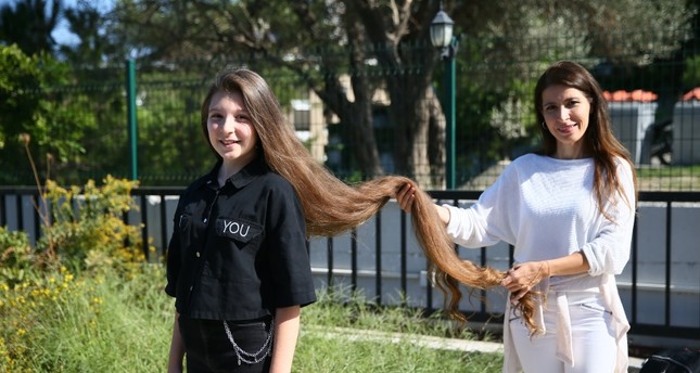 فتاة تركية تحطّم الرقم القياسي بطول الشعر (صورة) 1 الصبية بيلين أوزدمير صاحبة الشعر الطويل بصحبة أمها (الأناضول)