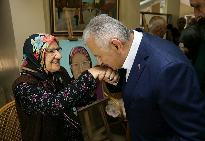 Yıldırım respectfully kisses the hand of an elderly woman during the Eid holiday.