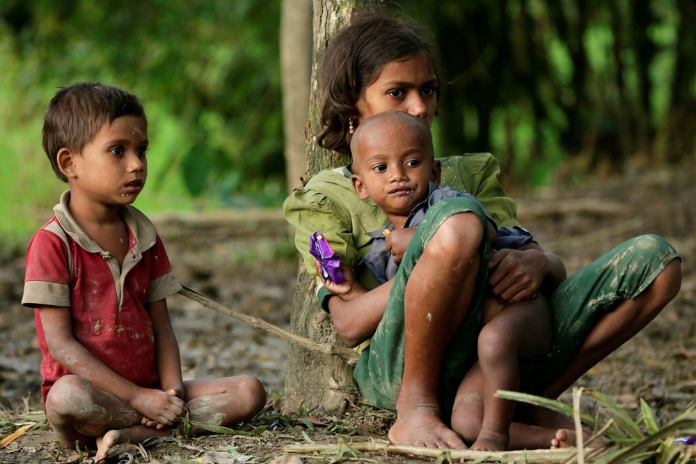 Rohingya children sit under a tree to take a upon arrival in Tuangiri, Teknaf, Bangladesh, Sept. 12.