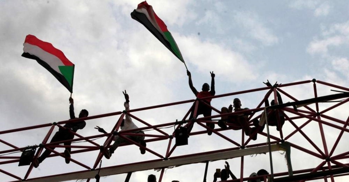 FILE PHOTO: Sudanese civilians wave their national flags during celebrations of the signing of the Sudan's power sharing deal, that paves the way for a transitional government, and eventually elections, following the overthrow of long-time leader Omar al-Bashir in Khartoum, Sudan, August 17, 2019. REUTERS/Mohamed Nureldin Abdallah/File Photo