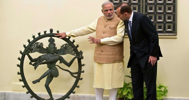 Indian Prime Minister Narendra Modi (L) and former Australian Prime Minister Tony Abbott talk alongside a statue of the Dancing Shiva ahead of a meeting in New Delhi.