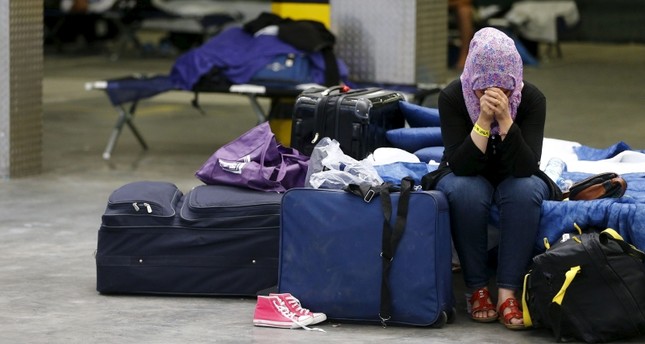 A Syrian woman cries as she sits on a folding bed in a former newspaper printing house used as a refugee registration centre for the German state of Hesse in Neu-Isenburg, on the outskirts of Frankfurt, Germany, September 11, 2015. (Reuters Photo)