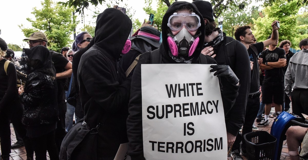 Members of the anti-fascist ANTIFA movement hold up signs against white supremacy during an alt-right rally, Portland, Oregon, Aug. 17, 2019.
