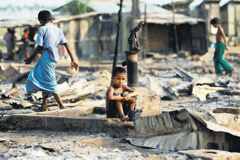 A boy looks on after a fire destroyed shelters at a camp for internally displaced Rohingya Muslims in the western Rakhine State near Sittwe, Myanmar.