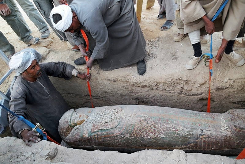 This photo released on Thursday, Feb. 13, 2014  shows Egyptian men digging up a preserved wooden sarcophagus that dates back to 1600 BC, when the Pharaonic 17th Dynasty reigned, in the ancient city of Luxor, Egypt. (AP Photo)