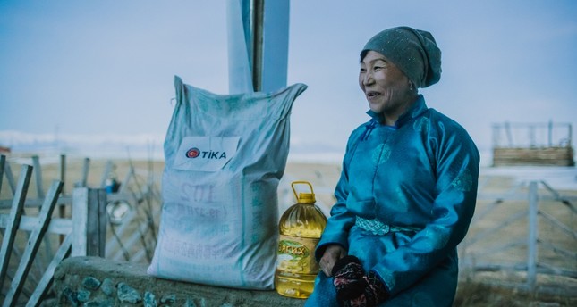 A Dukha woman sits next to food distributed by TÄ°KA in Tsagaannuur, Feb. 27, 2019.