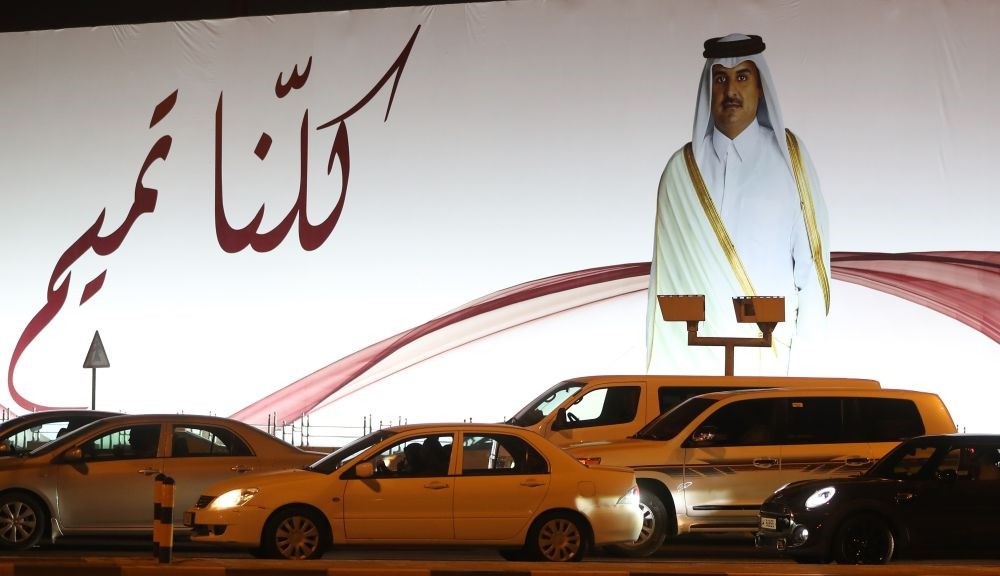 Photo shows a portrait of Qatar's Emir and text reading in Arabic: ,We are all Tamim, on a billboard outside the Qatar Sports club in Doha after the diplomatic crisis between Qatar and several other Gulf countries, June 11. 