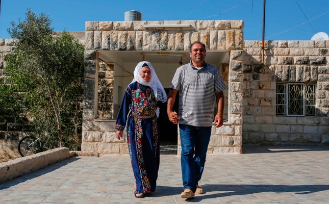 Muftia Tlaib, the maternal grandmother of U.S. Congresswoman Rashida Tlaib, walks with her son Bassam (R) outside their home in the village of Beit Ur al-Fouqa, in the occupied West Bank on August 15, 2019. (AFP Photo)