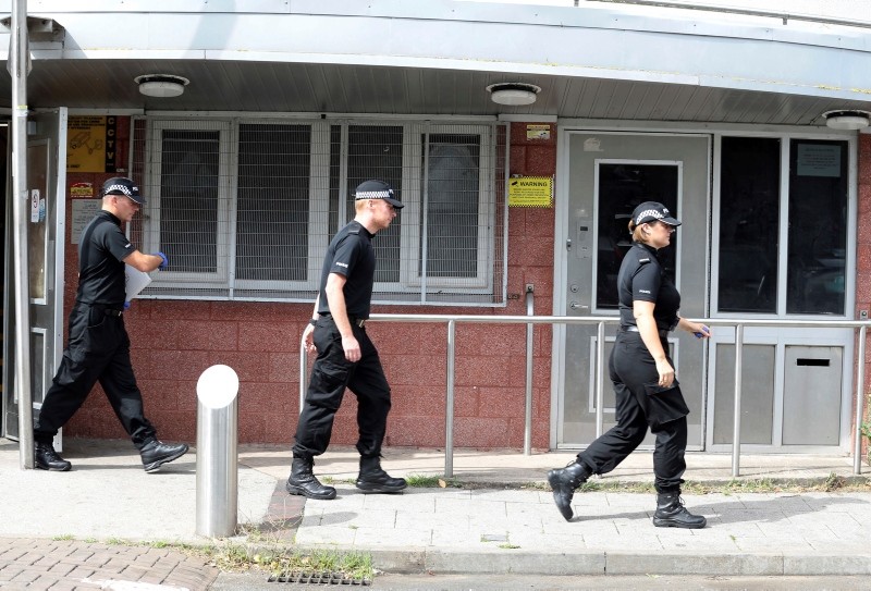 Police officers outside Brinklow Tower in Birmingham, England, where searches are being carried out in relation to the suspected terror attack on the Houses of Parliament in London, Wednesday Aug. 15, 2018. (Aaron Chown/PA via AP)