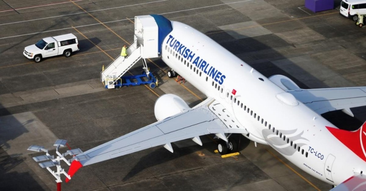 An aerial photo shows a worker climbing up to a Turkish Airlines Boeing 737 MAX airplane grounded at Boeing Field in Seattle, Washington, March 21, 2019. (Reuters Photo)