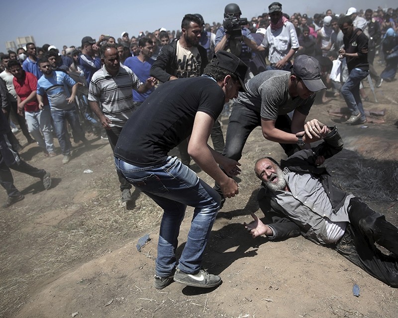 An elderly Palestinian man falls on the ground after being shot by Israeli troops during a deadly protest at the Gaza Strip's border with Israel, east of Khan Younis, Gaza Strip, Monday, May 14, 2018. (AP Photo)