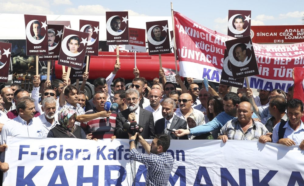 Protesters hold photos of people killed outside Aku0131ncu0131 Air Base on July 15, 2016, while AK Party lawmaker Taner Yu0131ldu0131z speaks in front of the courthouse where the coup suspects are on trial in Ankara.
