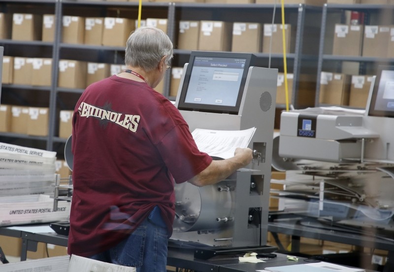An elections worker feeds ballots into a tabulation machine at the Broward County Supervisor of Elections office in Lauderhill, Fla., Nov. 10, 2018. (Getty Images/AFP)