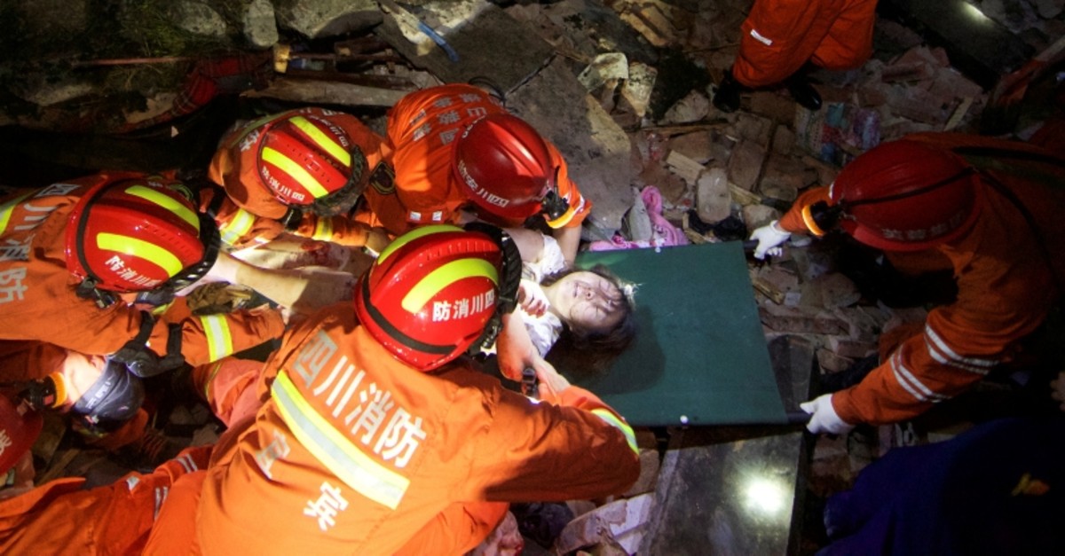 Rescue workers place a woman on a stretcher as they search for survivors in the rubble after earthquakes hit Changning county in Yibin, Sichuan province, China June 18, 2019. (Reuters Photo)