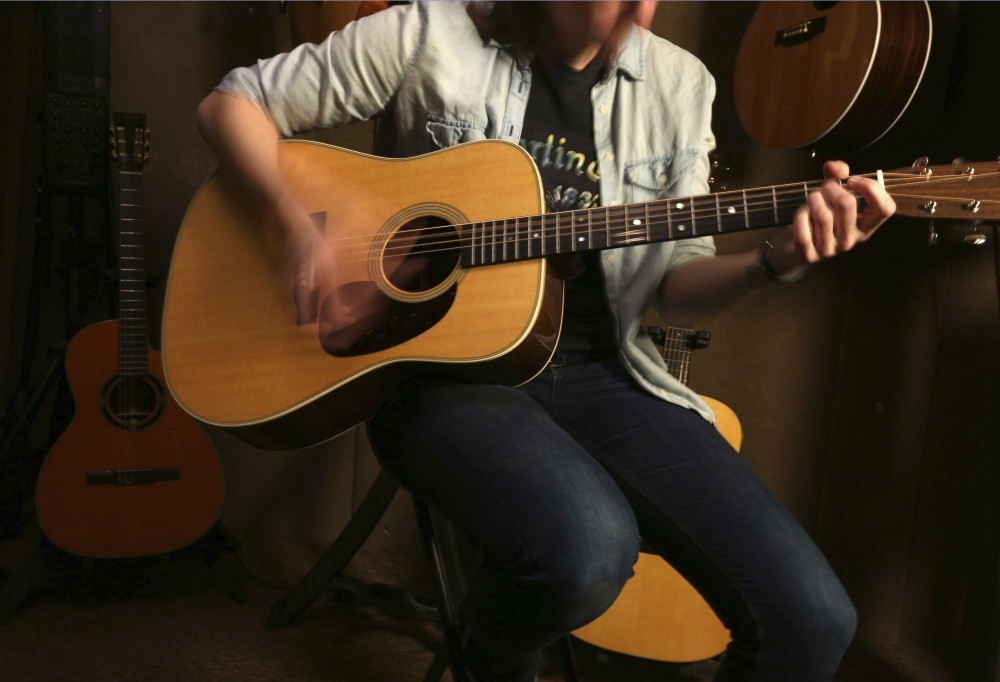 Employee Emily Meixell plays a guitar made with rosewood at C. F. Martin and Co., Pennsylvania.