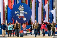 People walk in front of a 2018 FIFA World Cup decoration featuring the tournament mascot ,Zabivaka,, Moscow, June 7.