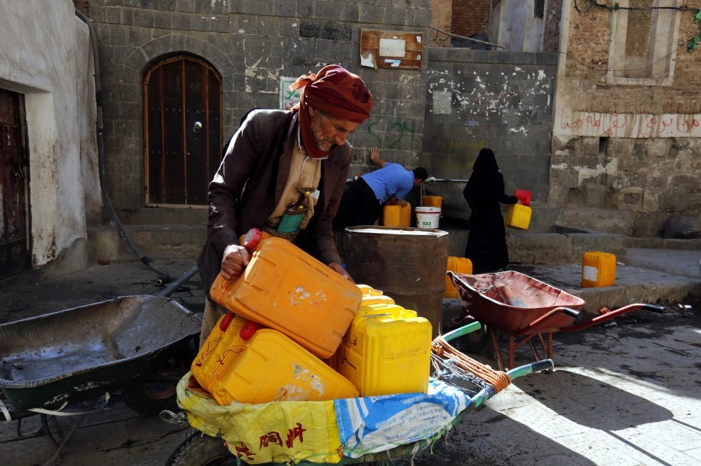 Yemenis fill jerry cans with drinking water from a donated source amid widespread disruption of water supplies in Sanaa, Dec. 9.