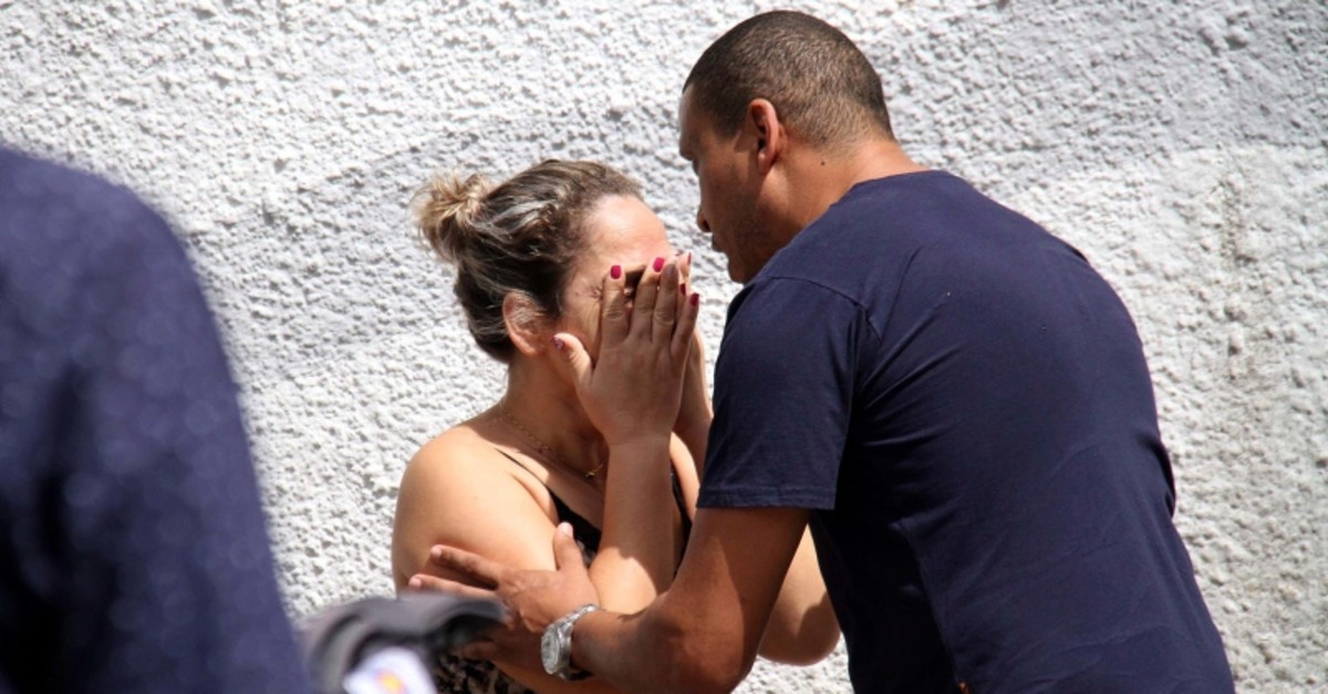 A man comforts a woman at the Raul Brasil State School in Suzano, Brazil, Wednesday, March 13, 2019. (AP Photo)