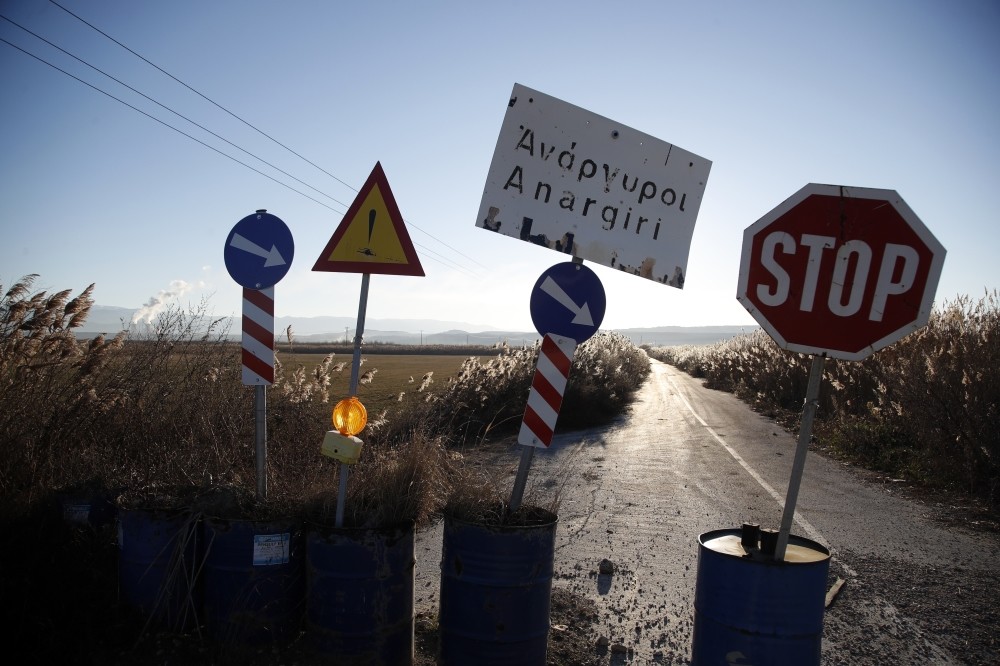 Signs close off a road damaged in a landslide in the village of Anargyri near the town of Amynatio, northern Greece.