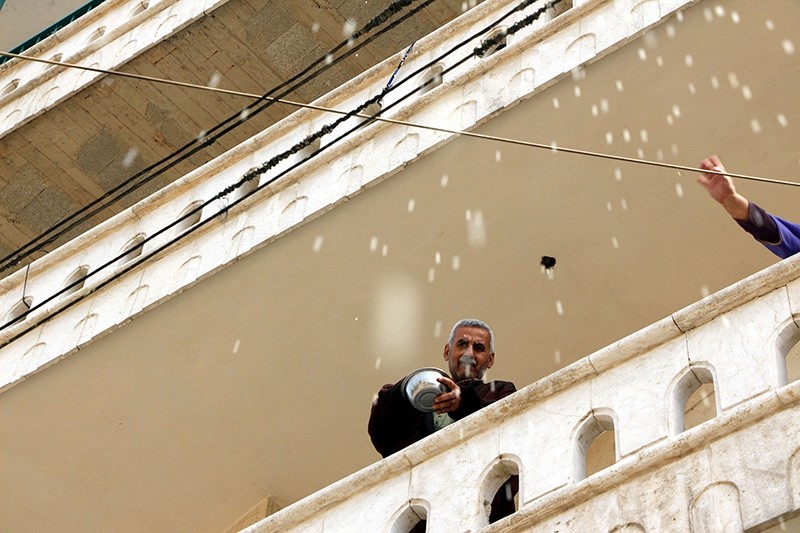 A local resident and his wife throw rice from their balcony to celebrate the liberation of Afrin from PKK/YPG terrorists on March 18, 2018 (DHA Photo)