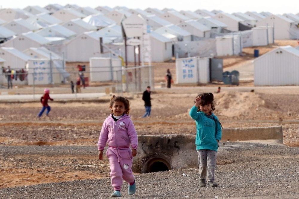 Syrian refugees standing at the Azraq refugee camp in northern Jordan.