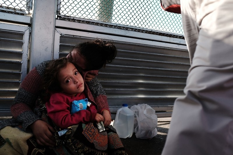 A Honduran child and her mother, fleeing poverty and violence in their home country, waits along the border bridge after being denied entry from Mexico into the U.S. on June 25, 2018 in Brownsville, Texas. (AFP Photo)