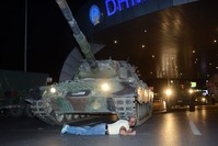 Metin Dou011fan, one of the civilians who went to the airport to confront the putschists, lies down in front of a tank commanded by the putschists at the airport, July 15, 2016.