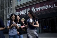 A group of women leave a mall after shopping in Beijing. China's industrial output, a key engine of growth, slowed sharply in July as government efforts to rein in debt weighed on demand and economic activity.