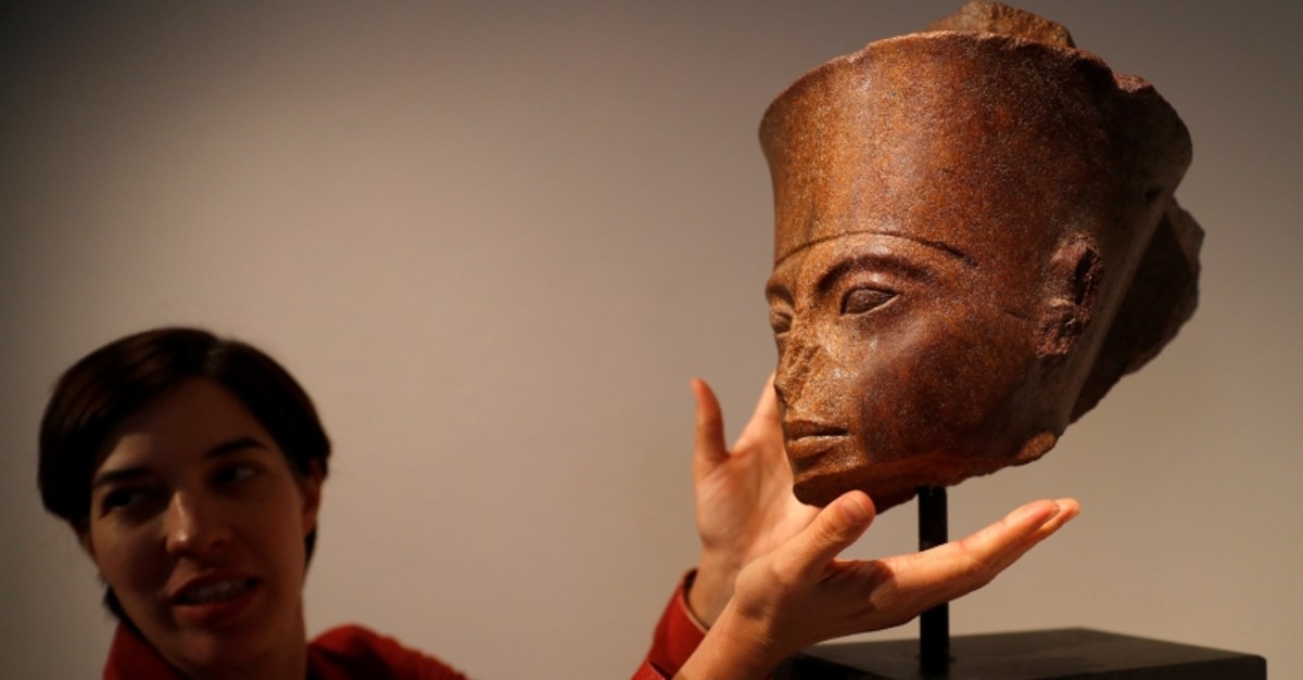 Laetitia Delaloye, head of antiquities of Christie's, poses for a photograph with an Egyptian brown quartzite head of Tutankhamun prior to its' sale at Christie's auction house in London, Britain, July 4, 2019. (Reuters Photo)