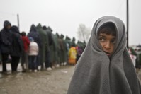 Migrant child covered in blanket stands in rain at the Greek border camp near Idomeni (AP File Photo)