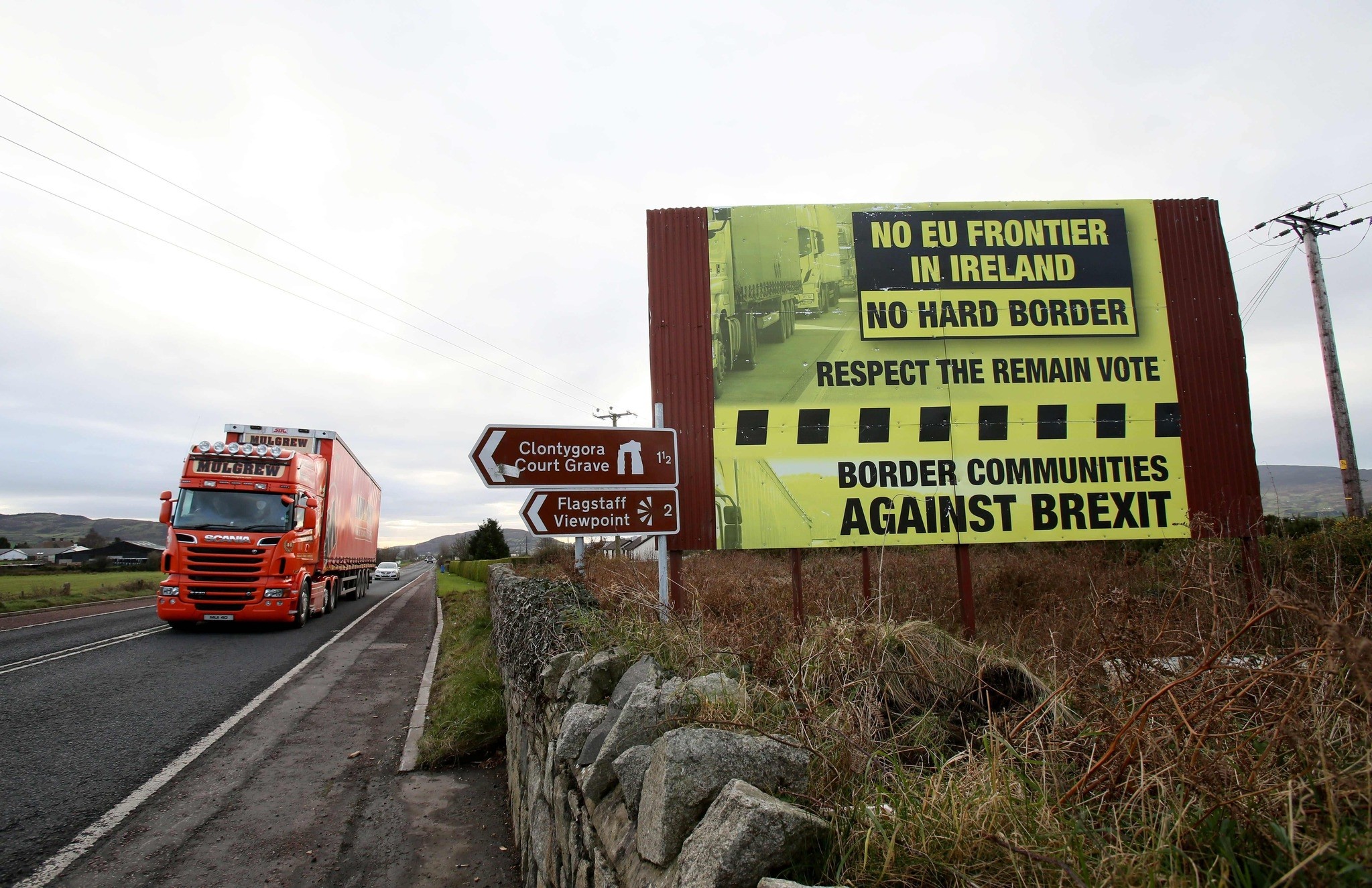 This photo shows traffic crossing the border into Northern Ireland from the Irish Republic alongside a Brexit Border poster on the Dublin road Co Armagh border, between Newry in Northern Ireland and Dundalk in the Irish Republic. (AFP Photo)