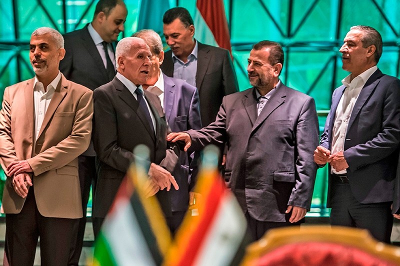 Fatah's Azzam al-Ahmad (C-L) speaks with Hamas' Saleh al-Aruri (C-R) after signing a reconciliation deal, Cairo, Egypt, Oct. 12, 2017. (AFP Photo)