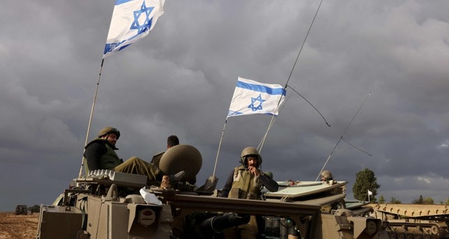 جنود إسرائيليون يجلسون فوق مركبات مدرعة أثناء انتشارهم بالقرب من حدود قطاع غزة، 20-11-2023 صورة: AFP