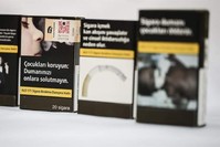 Flashy and colorful brand names were replaced by warning texts and pictures in the new plain packaging for cigarettes. (AA Photo)