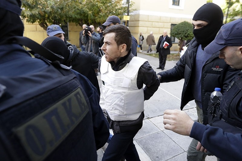 A Turkish suspect, no name available, is escorted by anti-terror police as he arrives at a court to face terrorism charges in Athens, Monday, Dec. 4, 2017. (AP Photo)