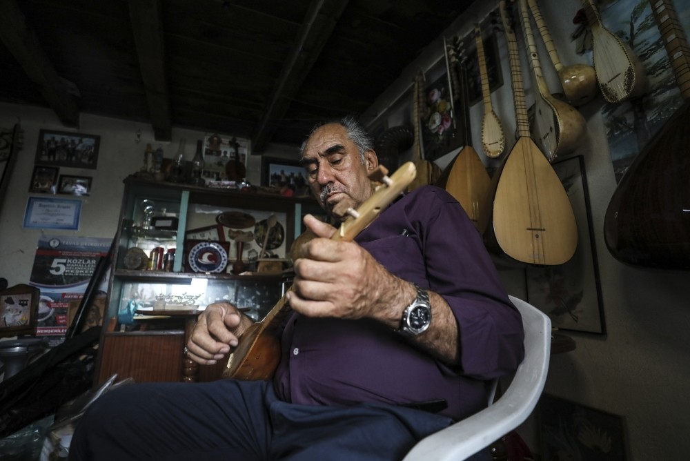Bayram Dev plays the instrument he produced in his workshop.
