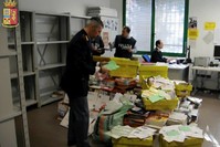 This frame made from a video by the Italian police made available Jan. 31, 2018 shows postal police officers sorting out undelivered mail found in a postman's garage, in Vicenza, northern Italy. (AP Photo)