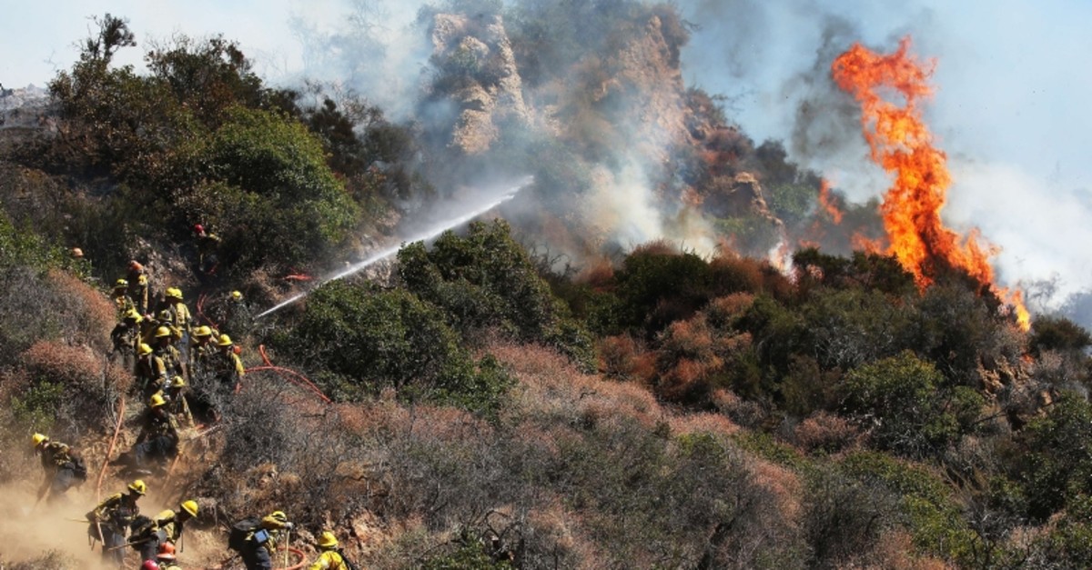 Firefighters work during a wildfire threatening nearby hillside homes in the Pacific Palisades neighborhood on October 21, 2019 in Los Angeles, California.  (AFP Photo)