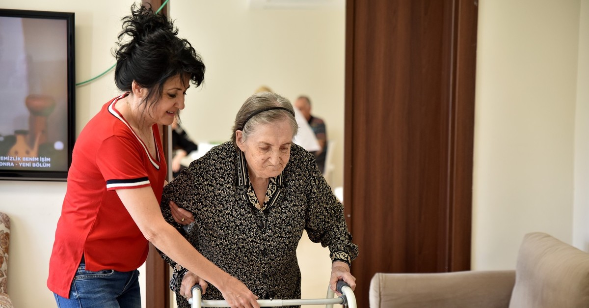 A carer helps an elderly woman at a retirement home for senior citizens in the western city of Eskiu015fehiru2019s Tepebau015fu0131 district, Sept. 20, 2019.