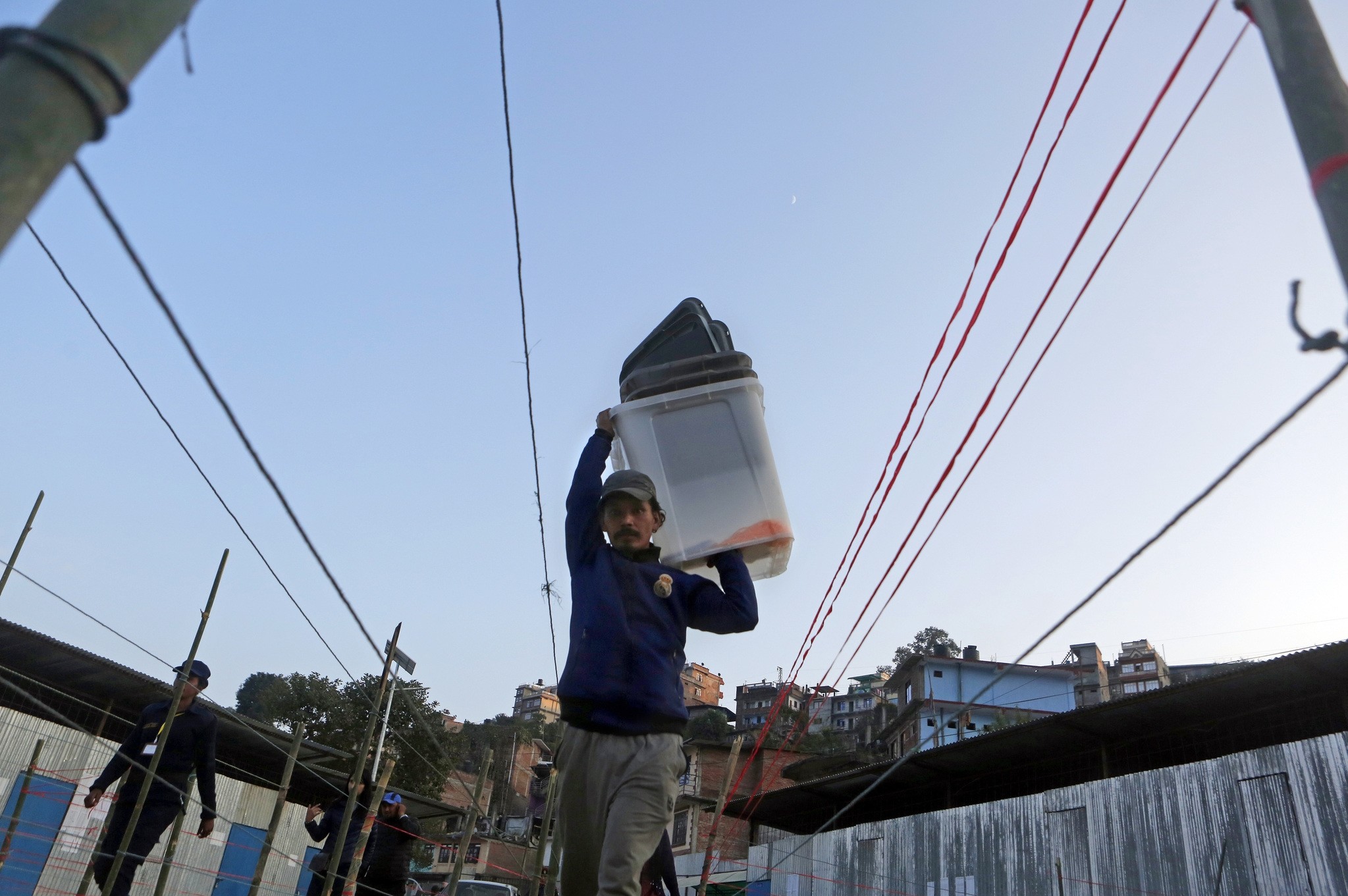 A Nepalese election commission staff member carries ballot boxes while setting up the polling station a day prior to legislative elections in Chautara, Nov. 25, 2017. (AP Photo)