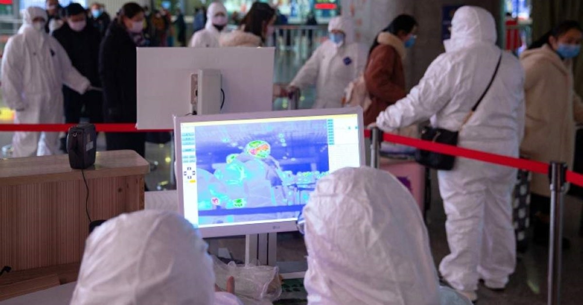 Workers in protective suits monitor a screen showing the thermal scan to check temperatures of passengers arriving at the Nanjing Railway Station, following the outbreak of a new coronavirus, in Nanjing, China Jan. 27, 2020. (Reuters Photo)