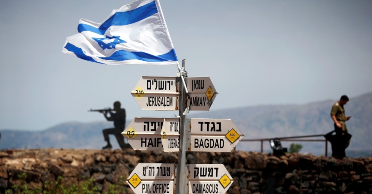 Israeli soldier stands next to signs pointing out distances to different cities, on Mount Bental, an observation post in the Israeli-occupied Golan Heights that overlooks the Syrian side of the Quneitra crossing, Israel May 10, 2018. (Reuters Photo)