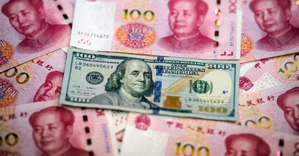 This photo illustration shows Chinese 100 yuan notes and a U.S. 100 dollar note in Beijing on Jan. 14, 2020. (AFP Photo)