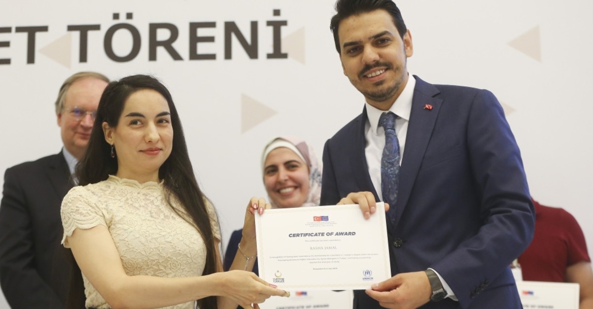 YTB chairman Abdullah Eren (right) gives a certificate to a newly graduated Syrian student at a ceremony in Ankara, July 4, 2019.