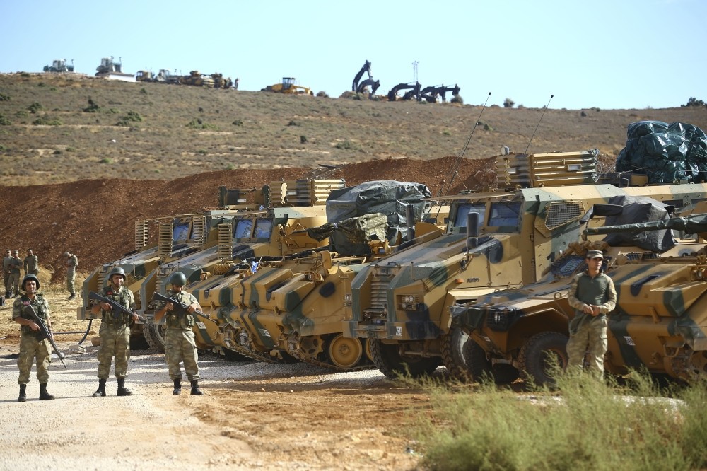 Turkish soldier and armored vehicles wait at the Syria-Turkey border in Hatay before the start of the operation.