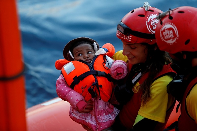 A crew member of MV Open Arms, the search and rescue ship of Proactiva Open Arms, carries a migrant baby before passing it to crew members of MV Aquarius (Reuters File Photo)