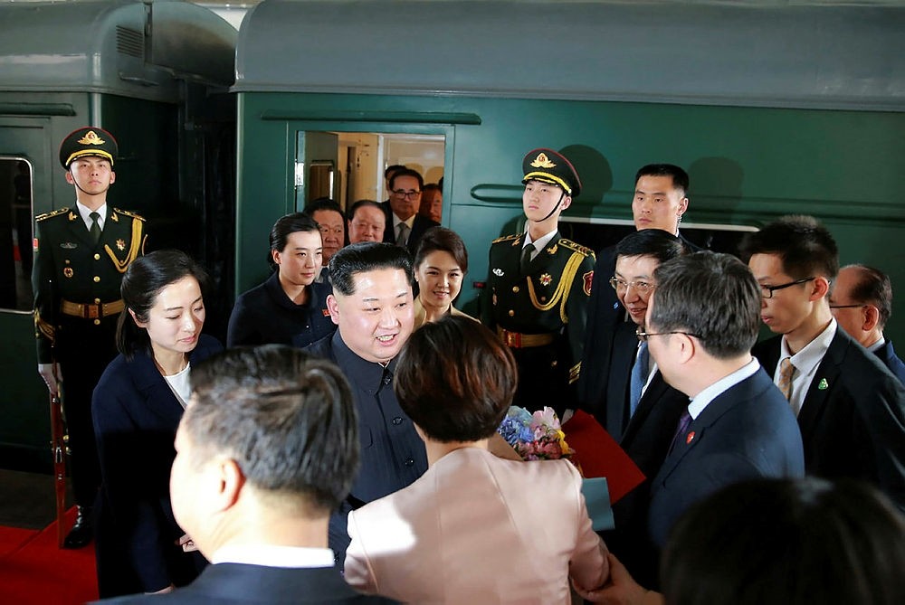 This picture from North Korea's official Korean Central News Agency (KCNA) taken on March 26, 2018 and released on March 28, 2018 shows North Korean leader Kim Jong Un (centre L) and his wife Ri Sol Ju (back centreR) arriving at Beijing railway station.